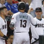 Arizona Diamondbacks' Nick Ahmed celebrates with David Peralta and Torey Lovullo (17) after hitting a solo home run against the Colorado Rockies during the third inning during a baseball game Tuesday, Aug. 20, 2019, in Phoenix. (AP Photo/Rick Scuteri)