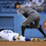 Los Angeles Dodgers' Russell Martin, left, slides in for a double as Arizona Diamondbacks second baseman Wilmer Flores loses the ball during the third inning of a baseball game Saturday, Aug. 10, 2019, in Los Angeles. (AP Photo/Mark J. Terrill)