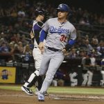 Los Angeles Dodgers' Joc Pederson (31) scores a run as Arizona Diamondbacks catcher Carson Kelly, left, waits for a late throw during the first inning of a baseball game Thursday, Aug. 29, 2019, in Phoenix. (AP Photo/Ross D. Franklin)