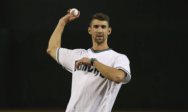 Swimmer Michael Phelps throws out the first pitch prior to a baseball game between the Arizona Diam...