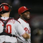 Philadelphia Phillies pitcher Hector Neris, right, smiles as he celebrates with Phillies catcher J.T. Realmuto (10) after the final out of a baseball game against the Arizona Diamondbacks, Monday, Aug. 5, 2019, in Phoenix. The Phillies defeated the Diamondbacks 7-3. (AP Photo/Ross D. Franklin)