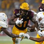 Arizona State running back Isaiah Floyd (31) runs with the ball as Kent State cornerback Jamal Parker (7) and linebacker Mandela Lawrence-Burke (28) attempt to make the tackle during the second half of an NCAA college football game Thursday, Aug. 29, 2019, in Tempe, Ariz. (AP Photo/Ralph Freso)