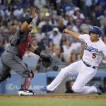 Los Angeles Dodgers' Corey Seager, right, scores on a sacrifice bunt by Kenta Maeda, of Japan, as Arizona Diamondbacks catcher Alex Avila takes the throw during the fourth inning of a baseball game Saturday, Aug. 10, 2019, in Los Angeles. (AP Photo/Mark J. Terrill)
