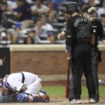 New York Mets catcher Tomas Nido falls to the ground after he was struck by the bat of Atlanta Braves' Josh Donaldson (20) during the sixth inning of a baseball game Friday, Aug. 23, 2019, in New York. (AP Photo/Mary Altaffer)