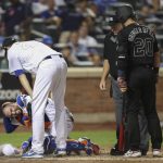 New York Mets starting pitcher Jacob deGrom, top left, checks on catcher Tomas Nido, who was hit by the bat of Atlanta Braves' Josh Donaldson (20) during the sixth inning of a baseball game Friday, Aug. 23, 2019, in New York. (AP Photo/Mary Altaffer)