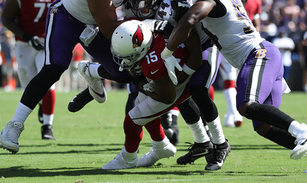 Wide receiver Michael Crabtree #15 of the Arizona Cardinals is tackled by multiple Baltimore Ravens...