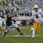 Arizona State quarterback Jayden Daniels, right, scrambles for a first down against Michigan State's Joe Bachie (35) and Kenny Willekes (48) late in the fourth quarter of an NCAA college football game, Saturday, Sept. 14, 2019, in East Lansing, Mich.  (AP Photo/Al Goldis)