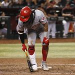 Cincinnati Reds' Freddy Galvis grabs his knee during an at bat against the Arizona Diamondbacks during the seventh inning of a baseball game Saturday, Sept. 14, 2019, in Phoenix. Galvis would leave the game due to injury. (AP Photo/Ross D. Franklin)