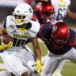 Northern Arizona wide receiver Brandon Porter (18) breaks a tackle from Arizona cornerback Malcolm Holland in the first half during an NCAA college football game, Saturday, Sept. 7, 2019, in Tucson, Ariz. (AP Photo/Rick Scuteri)
