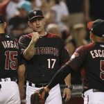 Arizona Diamondbacks manager Torey Lovullo (17) celebrate a win against the Cincinnati Reds with quality coach Robby Hammock, left, Ildemaro Vargas (15), and Eduardo Escobar (5) after a baseball game Saturday, Sept. 14, 2019, in Phoenix. The Diamondbacks defeated the Reds 1-0. (AP Photo/Ross D. Franklin)
