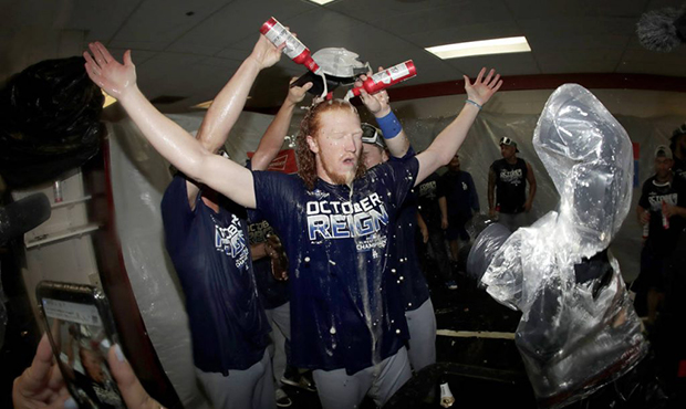 Los Angeles Dodgers pitcher Dustin May, center, is doused during a lockerroom celebration after the...