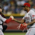 Cincinnati Reds relief pitcher Raisel Iglesias, right, shakes hands with catcher Tucker Barnhart after the team's baseball game against the Arizona Diamondbacks on Friday, Sept. 13, 2019, in Phoenix. The Reds won 4-3. (AP Photo/Ross D. Franklin)