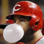 Cincinnati Reds' Eugenio Suarez blows a bubble as he waits to bat against the Arizona Diamondbacks during the third inning of a baseball game, Saturday, Sept. 14, 2019, in Phoenix. (AP Photo/Ross D. Franklin)