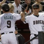 Arizona Diamondbacks' Josh Rojas (9) high-fives manager Torey Lovullo after scoring on a base hit by Jake Lamb during the first inning of a baseball game against the San Diego Padres on Tuesday, Sept. 3, 2019, in Phoenix. (AP Photo/Matt York)