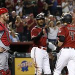 Arizona Diamondbacks' Wilmer Flores (41) celebrates his two-run home run against the St. Louis Cardinals with Adam Jones, middle, as Cardinals catcher Matt Wieters, left, pauses at home plate during the sixth inning of a baseball game Wednesday, Sept. 25, 2019, in Phoenix. (AP Photo/Ross D. Franklin)