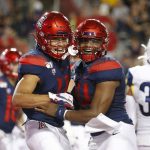 Arizona wide receiver Tayvian Cunningham (11) celebrates with Khalil Tate (14) after scoring a touchdown against Northern Arizona in the first half during an NCAA college football game, Saturday, Sept. 7, 2019, in Tucson, Ariz. (AP Photo/Rick Scuteri)