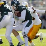 Michigan State quarterback Brian Lewerke (14) collides with teammate Matt Seybert, left, and is tackled by Arizona State's Tyler Whiley on a keeper during the first quarter of an NCAA college football game Saturday, Sept. 14, 2019, in East Lansing, Mich. (AP Photo/Al Goldis)