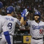 Los Angeles Dodgers' Russell Martin (55) celebrates his home run against the Arizona Diamondbacks with teammates Ross Stripling, center, and A.J. Pollock (11) during the third inning of a baseball game Sunday, Sept. 1, 2019, in Phoenix. (AP Photo/Ross D. Franklin)