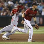 Arizona Diamondbacks third baseman Jake Lamb, right, runs after a late throw as St. Louis Cardinals' Jose Martinez (38) slides into third base with a triple during the fifth inning of a baseball game Wednesday, Sept. 25, 2019, in Phoenix. (AP Photo/Ross D. Franklin)