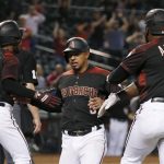 Arizona Diamondbacks' Eduardo Escobar, middle, celebrates with Jarrod Dyson (1) and Abraham Almonte (48) after all score runs against the Miami Marlins on a three-run double hit by Diamondbacks' Jake Lamb during the seventh inning of a baseball game, Monday, Sept. 16, 2019, in Phoenix. (AP Photo/Ross D. Franklin)