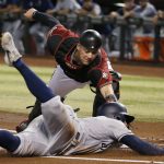 Arizona Diamondbacks catcher Carson Kelly, top, tags out San Diego Padres' Greg Garcia at home during the first inning of a baseball game Wednesday, Sept. 4, 2019, in Phoenix. (AP Photo/Ross D. Franklin)