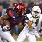 Arizona running back Gary Brightwell (23) runs away from Northern Arizona defensive back Anthony Sweeney in the second half during an NCAA college football game, Saturday, Sept. 7, 2019, in Tucson, Ariz. (AP Photo/Rick Scuteri)