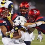 Northern Arizona wide receiver Brandon Porter (18) tries to breaks tackles from Arizona safety Chacho Ulloa (13) and Malcolm Holland (10) in the first half during an NCAA college football game, Saturday, Sept. 7, 2019, in Tucson, Ariz. (AP Photo/Rick Scuteri)