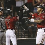 Arizona Diamondbacks' Ketel Marte, right, celebrates his grand slam with Jarrod Dyson (1) as San Diego Padres catcher Austin Hedges, left, pauses at home plate during the seventh inning of a baseball game Wednesday, Sept. 4, 2019, in Phoenix. (AP Photo/Ross D. Franklin)