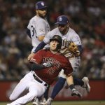 Arizona Diamondbacks' Nick Ahmed, front, is tagged out in a rundown by San Diego Padres second baseman Greg Garcia, middle, as Padres first baseman Eric Hosmer watches during the seventh inning of a baseball game Wednesday, Sept. 4, 2019, in Phoenix. The Diamondbacks won 4-1. (AP Photo/Ross D. Franklin)