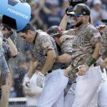San Diego Padres' Seth Mejias-Brean, second from left, is doused in a celebration at the plate with teammates after hitting a walkoff two-run home run against the Arizona Diamondbacks during the 10th inning of a baseball game in San Diego, Sunday, Sept. 22, 2019. (AP Photo/Alex Gallardo)