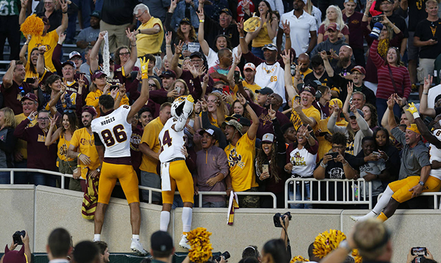 Arizona State players celebrate with fans following an NCAA college football game against Michigan ...