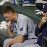 San Diego Padres starting pitcher Eric Lauer, left, sits with Padres pitching coach Darren Balsley, right, after Lauer is taken out of the game during the fifth inning of a baseball game against the Arizona Diamondbacks, Friday, Sept. 27, 2019, in Phoenix. (AP Photo/Ross D. Franklin)