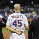 New York Mets pitcher Zack Wheeler (45) stands between two uniformed officers during a Sept. 11, 2001. tribute before the team's baseball game against the Arizona Diamondbacks on Wednesday, Sept. 11, 2019, in New York. (AP Photo/Kathy Willens)