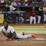 St. Louis Cardinals' Randy Arozarena, left, and Arizona Diamondbacks catcher Caleb Joseph, right, wait for the umpire to make a call at home plate during the fourth inning of a baseball game Wednesday, Sept. 25, 2019, in Phoenix. Arozarena was ruled safe at home for a run scored against the Diamondbacks. (AP Photo/Ross D. Franklin)