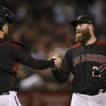 Arizona Diamondbacks relief pitcher Archie Bradley, right, slaps hands with Diamondbacks catcher Carson Kelly, left, after the final out in the ninth inning of a baseball game Saturday, Sept. 14, 2019, in Phoenix. The Diamondbacks defeated the Reds 1-0. (AP Photo/Ross D. Franklin)