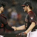 Arizona Diamondbacks relief pitcher Kevin Ginkel, right, shakes hands with catcher Carson Kelly, left, after the final out in the ninth inning of a baseball game against the Miami Marlins, Monday, Sept. 16, 2019, in Phoenix. The Diamondbacks defeated the Marlins 7-5. (AP Photo/Ross D. Franklin)