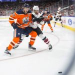 Arizona Coyotes right wing Vinnie Hinostroza (13) and Edmonton Oilers centre Connor McDavid (97) vie for the puck during the first period of an NHL hockey preseason game Tuesday, Sept. 24, 2019, in Edmonton, Alberta. (Amber Bracken/The Canadian Press via AP)