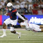 Arizona wide receiver Brian Casteel (5) tries to elude the tackle of Texas Tech defensive back Thomas Leggett (16) during the first half of an NCAA college football game, Saturday, Sept. 14, 2019, in Tucson, Ariz. (AP Photo/Ralph Freso)