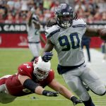 Seattle Seahawks outside linebacker Jadeveon Clowney (90) runs back an interception for a touchdown as Arizona Cardinals offensive guard J.R. Sweezy (64) defends during the first half of an NFL football game, Sunday, Sept. 29, 2019, in Glendale, Ariz. (AP Photo/Rick Scuteri)