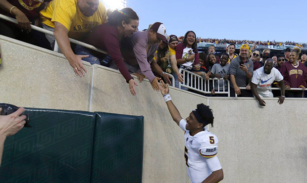 Arizona State quarterback Jayden Daniels celebrates with fans following an NCAA college football ga...