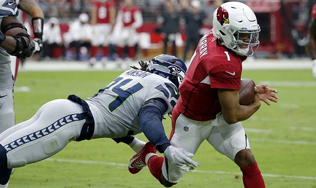 Arizona Cardinals quarterback Kyler Murray (1) eludes the reach of Seattle Seahawks defensive end E...
