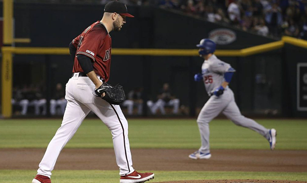 Arizona Diamondbacks starting pitcher Alex Young, left, walks back on the mound after giving up a h...