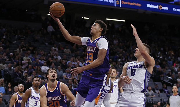 Phoenix Suns forward Cameron Johnson, center, goes to the basket past Sacramento Kings guard Bogdan...
