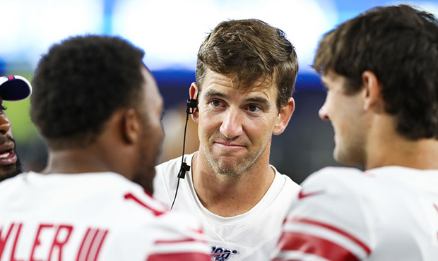 Eli Manning #10 of the New York Giants talk to his teammates during a preseason game against the Ne...