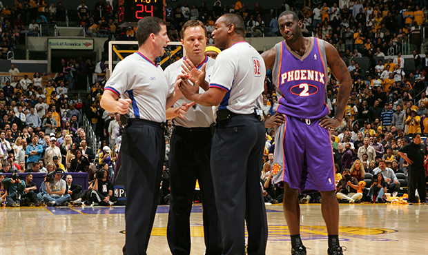 Tim Thomas #2 (R) of the Phoenix Suns looks in on referees (L-R) Tim Donaghy #21, Bill Spooner #22 ...