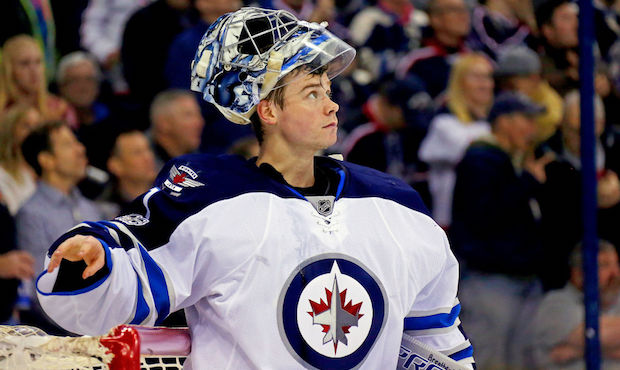 Eric Comrie #1 of the Winnipeg Jets watches a replay after letting in a goal while making his NHL d...