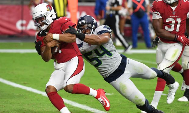 Kyler Murray #1 of the Arizona Cardinals scores a rushing touchdown while avoiding a tackle by Bobb...