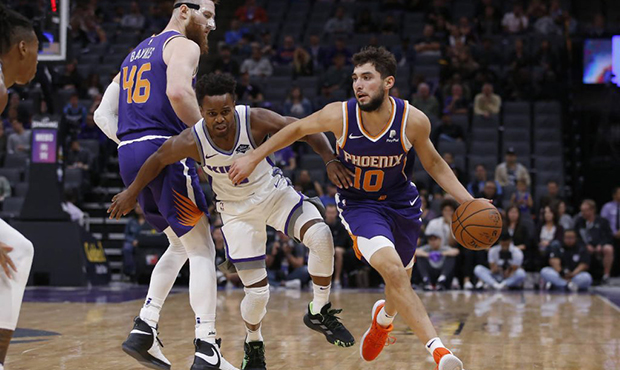 Sacramento Kings guard Yogi Ferrell, center, fights through the screen set by Phoenix Suns center A...