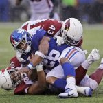 New York Giants' Saquon Barkley, center, is brought down by Arizona Cardinals defense during the second half of an NFL football game, Sunday, Oct. 20, 2019, in East Rutherford, N.J. (AP Photo/Adam Hunger)