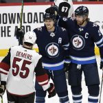 Winnipeg Jets' Mark Scheifele (55) celebrates his goal with teammate Blake Wheeler (26) during the first period of an NHL hockey game against the Arizona Coyotes on Tuesday, Oct. 15, 2019, in Winnipeg, Manitoba. (Fred Greenslade/The Canadian Press via AP)